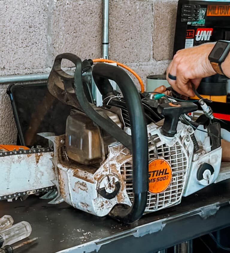 man repairing a chainsaw